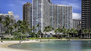 A beachfront hotel with multiple high-rise buildings, palm trees, and a sandy beach. - Ilikai by Luana Hawaii Vacation Rentals (Honolulu)