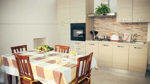Una cuina moderna amb armaris de fusta, forn de pared i fogó a gas.