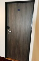 A dark wooden door with a number plate, a keyhole, and a door handle.