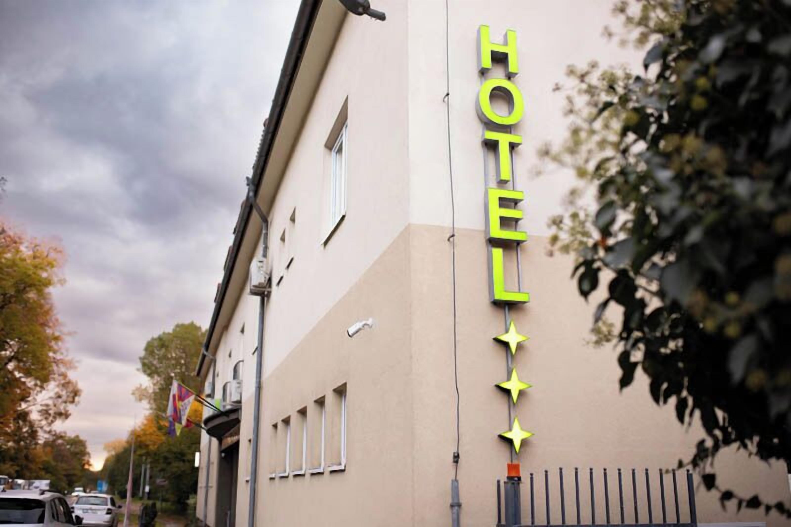 Un letrero de hotel con diseño moderno, que incluye un letrero de neón y estrellas decorativas.