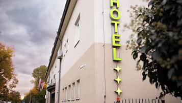 Un letrero de hotel con diseño moderno, que incluye un letrero de neón y estrellas decorativas.