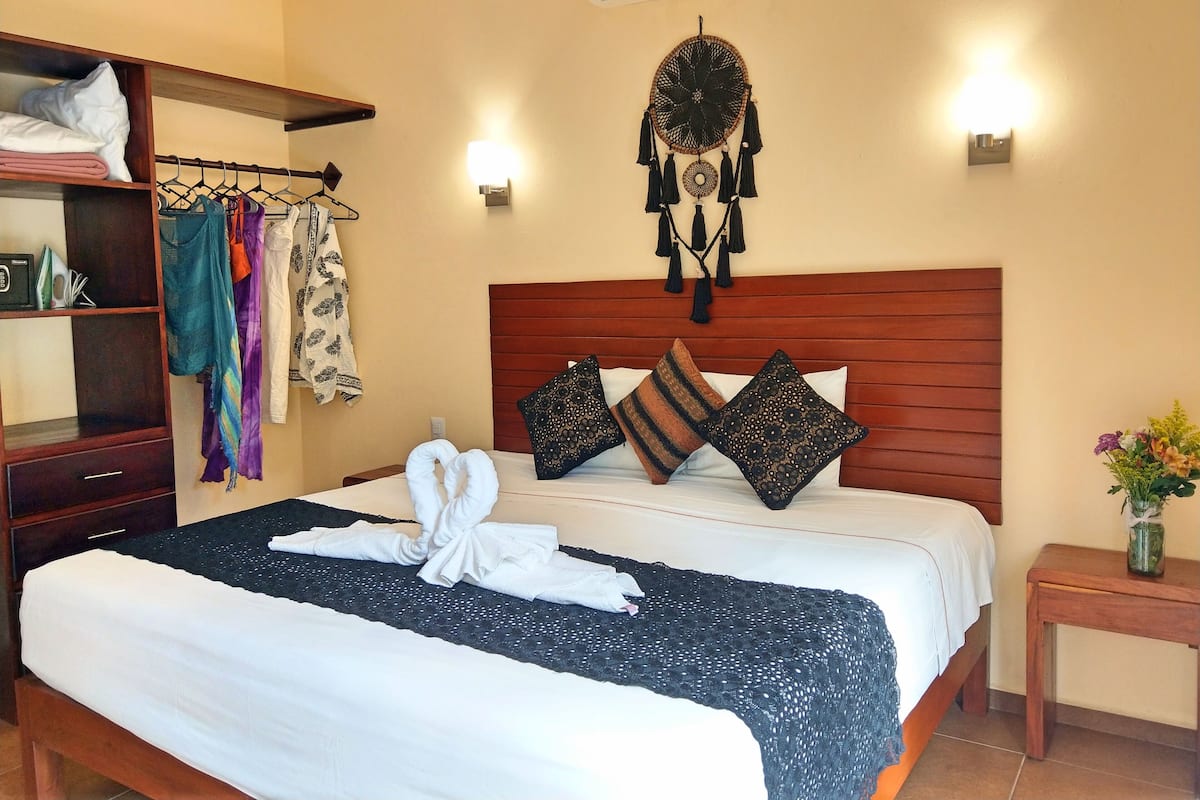 A neatly made bed with white and black bedding, a wooden headboard, and decorative pillows.
