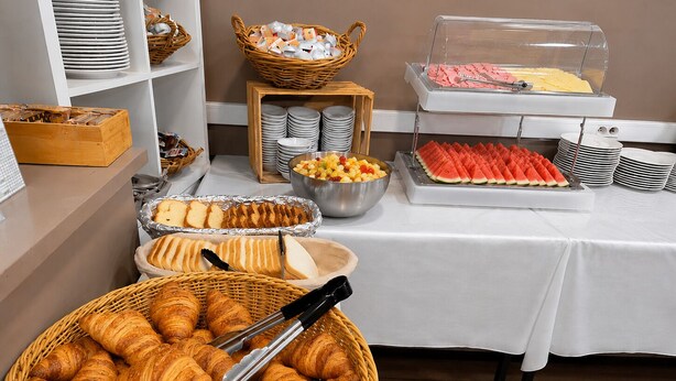 A buffet setup with croissants, fruit, and a variety of other foods. - Hôtel Hélianthe (Lourdes)