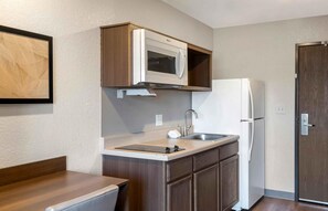 A compact kitchenette with a built-in microwave, a stainless steel sink, and a white refrigerator. - Extended Stay America Select Suites - Charlotte - Northlake (Charlotte)