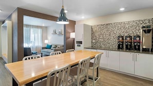 A modern kitchen with a dining area, equipped with coffee machines and a water dispenser. - Extended Stay America Suites - Charlotte - Matthews (Matthews)