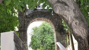 Una escalera de piedra con balaustres blancos que conduce a un arco.