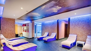 Un área de spa con sillones de masaje, una recepción y una pared con textura.