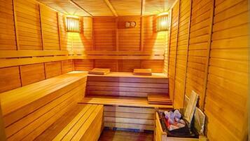 Una sauna de madera con bancos y un asiento de banco, paredes de madera y un asiento con toallas.
