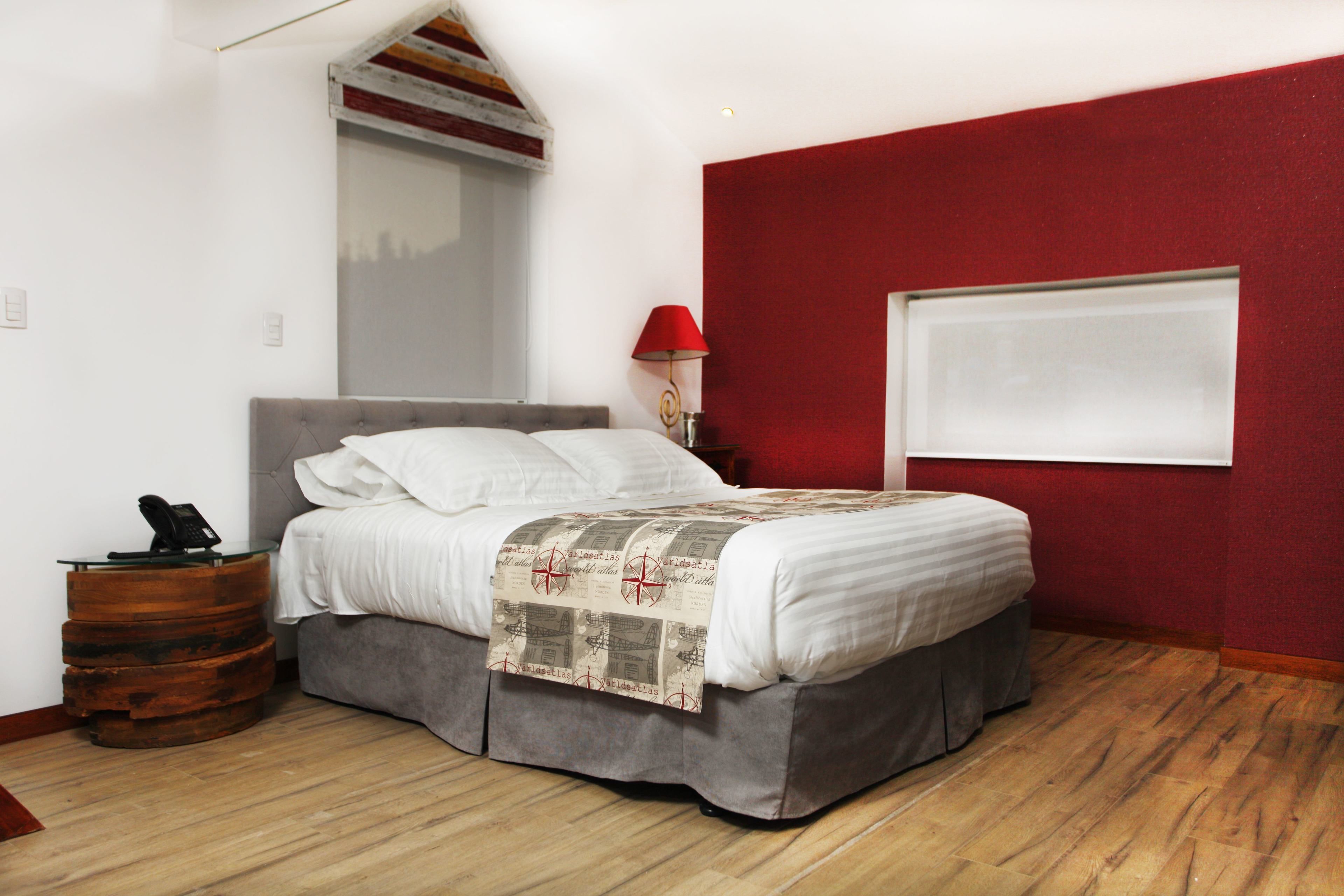 Un dormitorio moderno con una cama, una mesita de noche, una lámpara y una ventana.