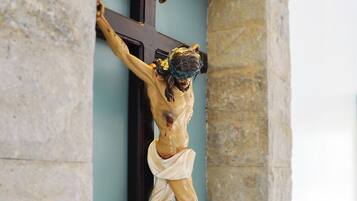 A crucifix mounted on a wall with stone masonry.
