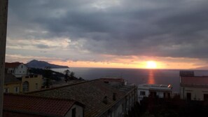 A coastal sunset view with buildings in the foreground. - Sunset Rooms (Massa Lubrense)