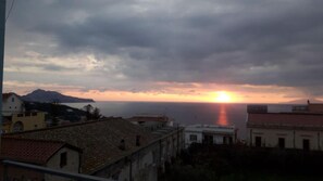 A coastal view with buildings and mountains in the background. - Sunset Rooms (Massa Lubrense)