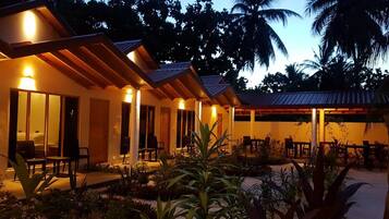 A resort with multiple rooms, each with a balcony and a view of the surrounding garden.