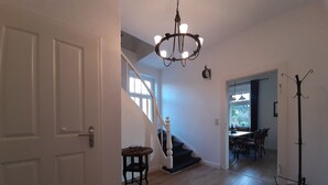 A spacious hallway with a staircase leading to a dining area. - Ferienwohnung Stricker Bad Sachsa (Bad Sachsa)