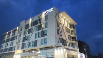 A multi-story hotel with a prominent 'Premier' sign, large windows, and a flat roof design.