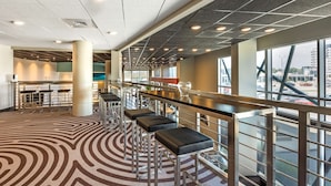 A modern bar area with high stools and a patterned carpet.