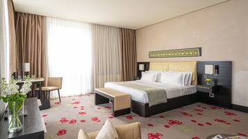 Deluxe kamer | Luxe beddengoed, een minibar, een kluis op de kamer, een bureau