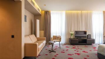 Deluxe Room | Living area | 50-inch Smart TV with cable channels