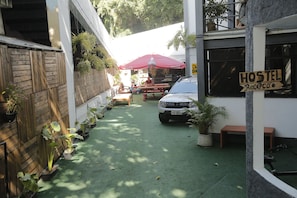 Un hostal con recepción, mobiliario exterior y plantas en macetas.