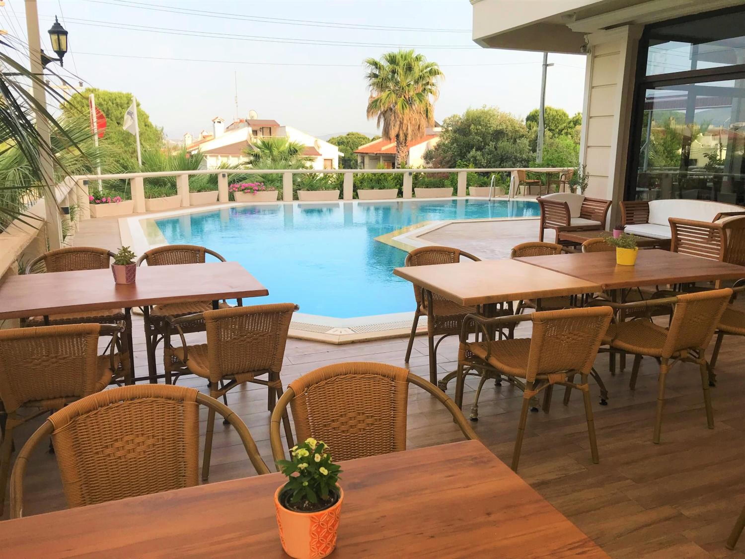 A poolside area with wicker furniture and a view of the pool.