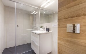 Apartamento design | Banheiro | Chuveiro, secador de cabelo, toalhas de banho, papel higiênico