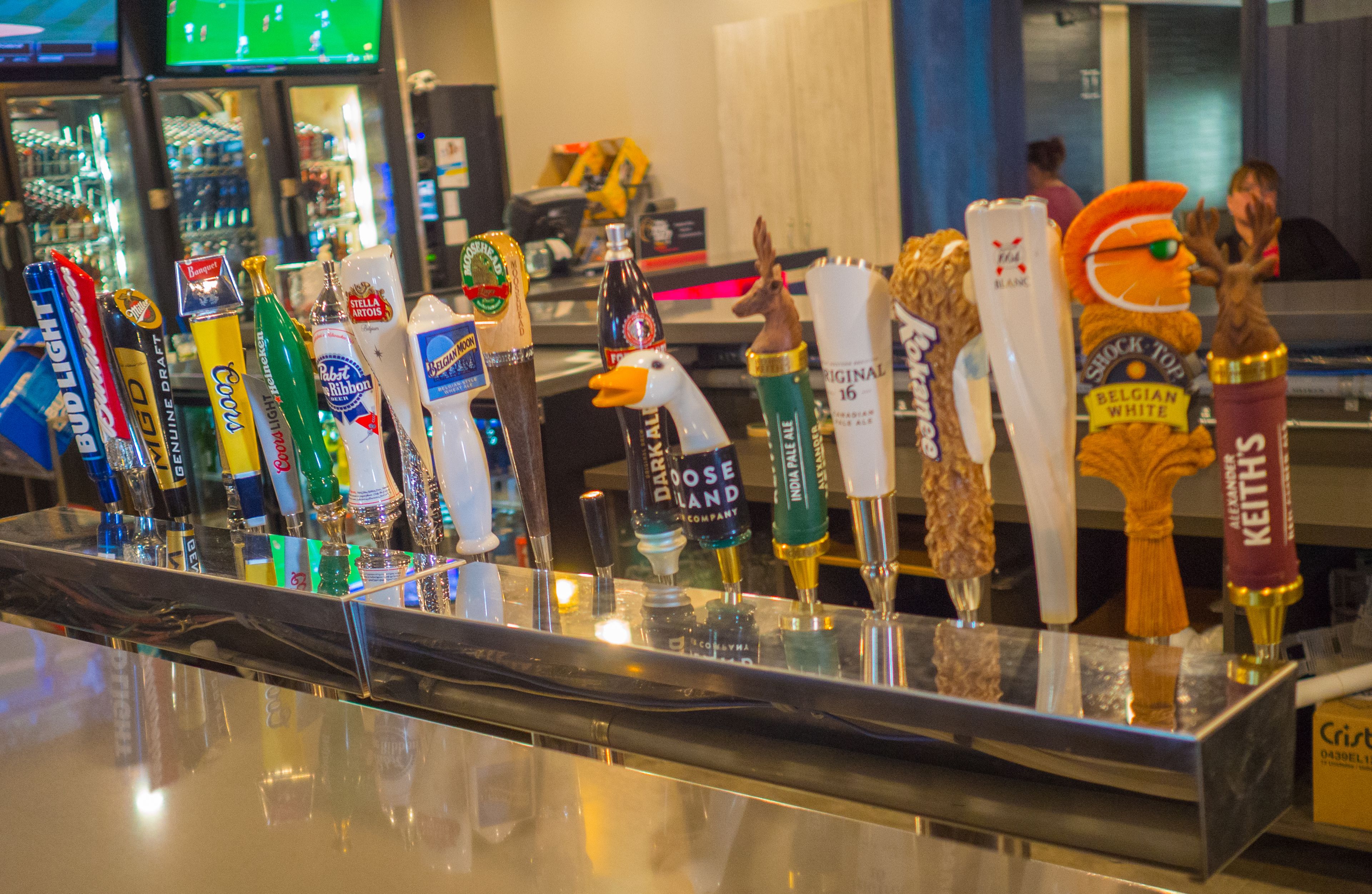 A bar with a variety of beer taps, including brands like Bud Light and Coors Light.