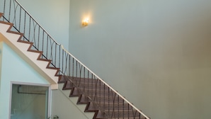 A staircase with a checkered floor, a chandelier, and a seating area with chairs and a table. - The New Cavalier Inn (Winnipeg)
