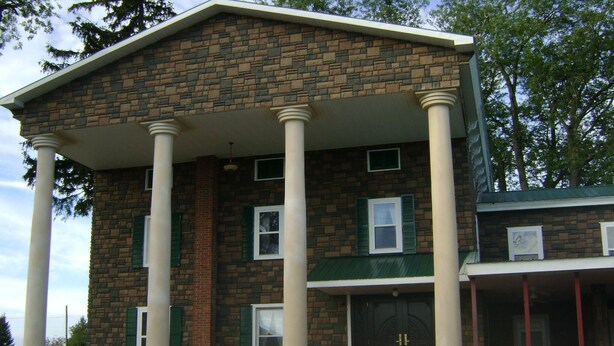A two-story building with a brick facade, white columns, and green shutters. - Room #7 We are only 30 min. away from  "BASEBALL HALL OF FAME" in Coopers Town . (Fort Plain)