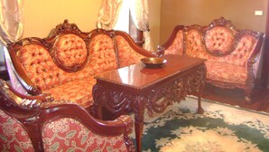A room with ornate wooden furniture, including a sofa and a table with a decorative bowl. - Room #7 We are only 30 min. away from  "BASEBALL HALL OF FAME" in Coopers Town . (Fort Plain)