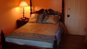 A four-poster bed with a wooden headboard, a bedside table with a lamp, and a door to the right. - Room #7 We are only 30 min. away from  "BASEBALL HALL OF FAME" in Coopers Town . (Fort Plain)