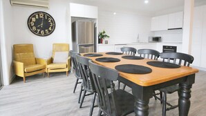 Cozinha moderna com armários brancos, geladeira de aço inoxidável e micro-ondas.