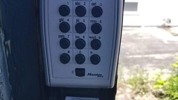 A keypad with a manual and a label indicating "OPEN/OUVRIR/ABRIR" and "CLOSE/FERMER/CERRAR".