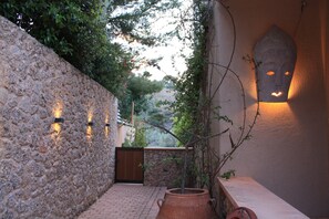 Stroll through a peaceful outdoor space with a stone wall and a covered entrance.