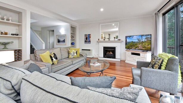 A modern living room with a fireplace, a television, and a large window.