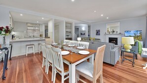 A modern living space with a dining area, kitchen, and a fireplace.