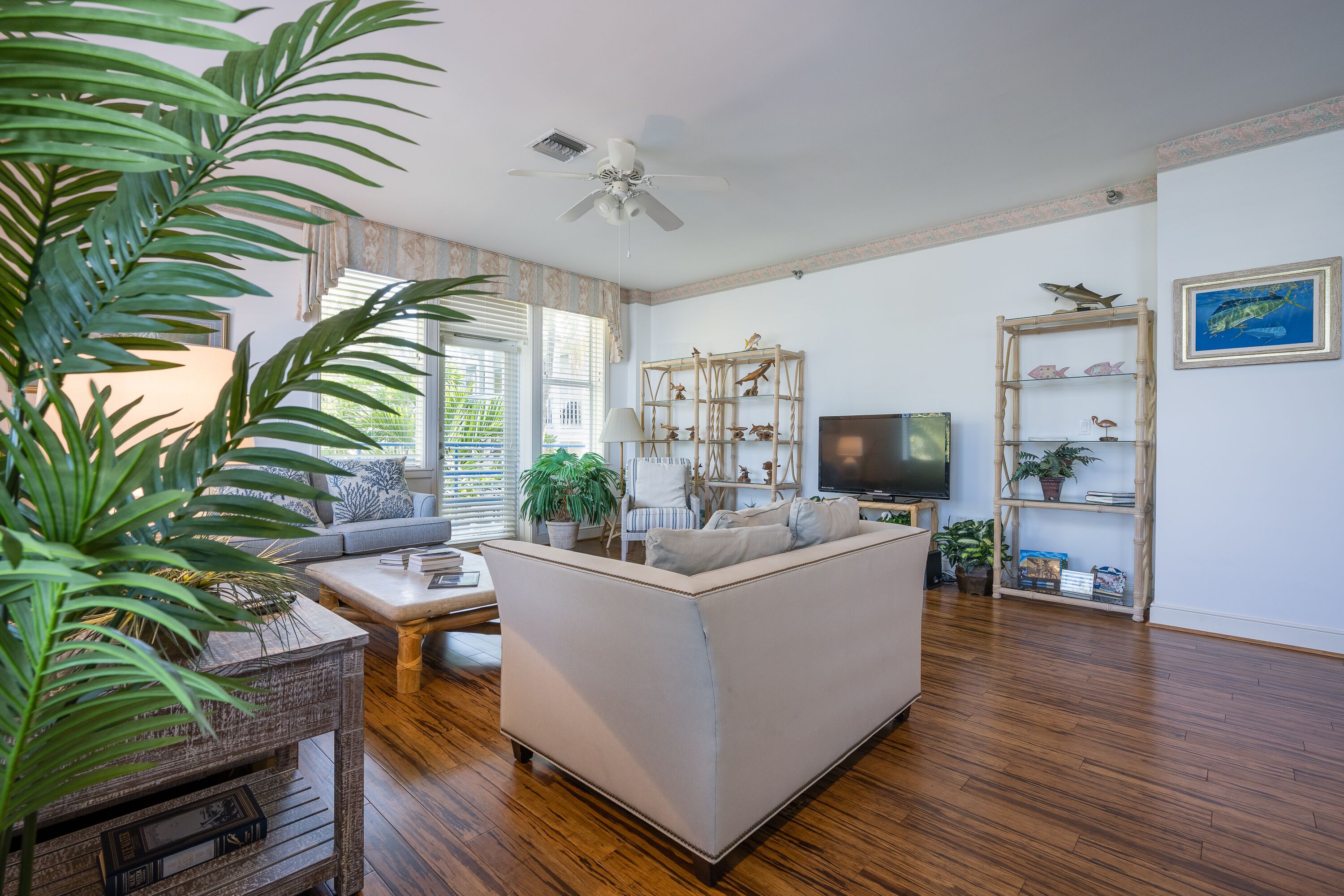 A living room with a sofa, a coffee table, a TV, and a bookshelf.