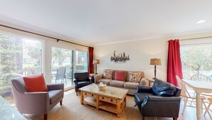 A spacious living room with a sofa set, a coffee table, and a dining area with a table and chairs. - Very peaceful and tranquil setting. (Hilton Head)
