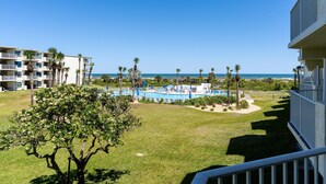 Un resort con piscina, palmeras y vista al océano.