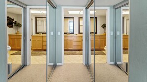 A modern kitchen with wooden cabinets, a central island, and a large mirror. - Updated 2 BR! Breathtaking View of the Gulf Sunsets! B1113A (Cape Haze)