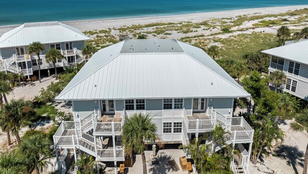 A large beachfront hotel with multiple balconies, a flat roof, and a view of the ocean. - Updated 2 BR! Breathtaking View of the Gulf Sunsets! B1113A (Cape Haze)