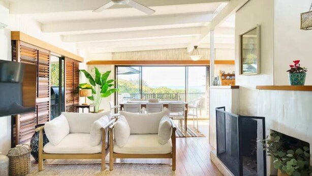 A modern living room with a sofa, a TV, and a fireplace. - AZURE - BEACH HOUSE ON THE BEACH (Marcus Beach)
