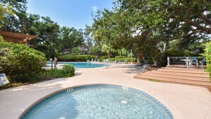 Une piscine avec des chaises longues et une terrasse en bois.