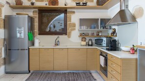 Een moderne keuken met een koelkast, magnetron, fornuis en houten kastjes.