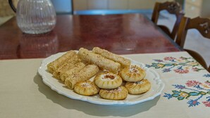 Een eettafel met een bord gebakjes en een koffiepot.