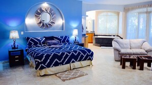 A modern bedroom with a large bed, a sofa, and a dining area. - SOUTH BEACH PARADISE! DIRECT OCEANFRONT WITH COMPLIMENTARY DAILY CHEF BREAKFAST! (Jaco Beach)