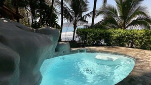 A hot tub with a clear view of the ocean and palm trees in the background. - SOUTH BEACH PARADISE! DIRECT OCEANFRONT WITH COMPLIMENTARY DAILY CHEF BREAKFAST! (Jaco Beach)
