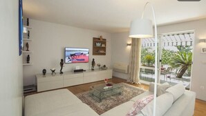 A modern living room with a sofa, coffee table, TV, and shelves with decorative items. - Deluxe apartment Lea with large garden (Split)