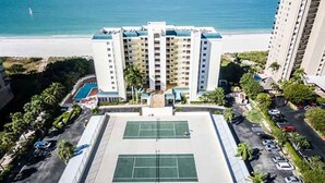 A multi-story hotel with a tennis court and a pool. - Magnificent beachfront condo w/ pool & parking at Apollo Condominium (Marco Island)
