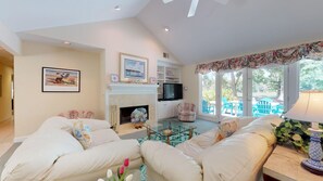 A spacious living room with a fireplace, comfortable seating, and a television.