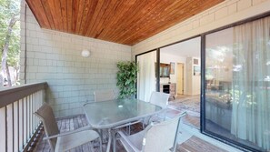 Relax in this serene outdoor space with a glass-top table and wicker chairs.